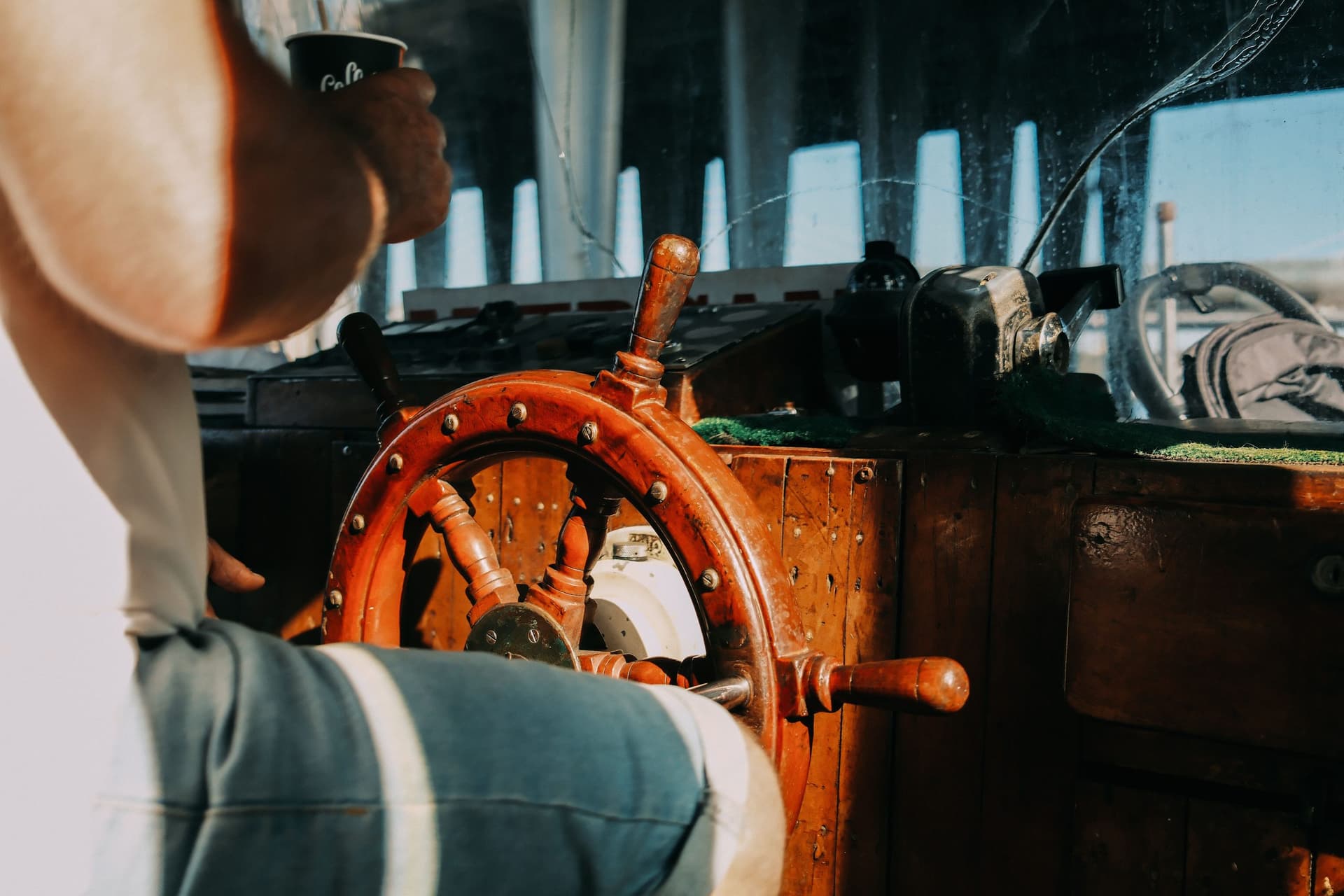 Hands on the wheel of a sailing ship