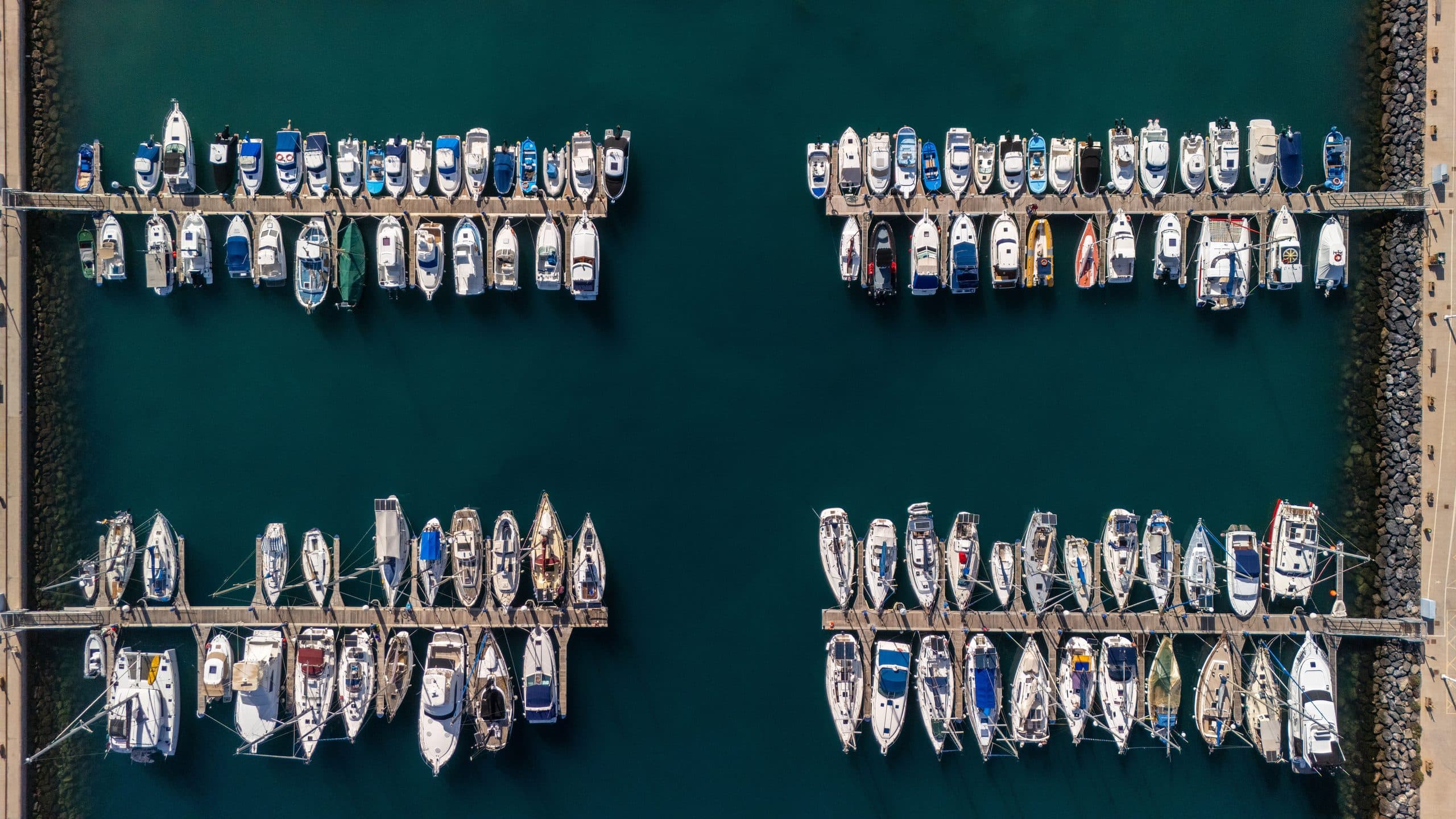 Rows of boats docked in a marina, seen from above