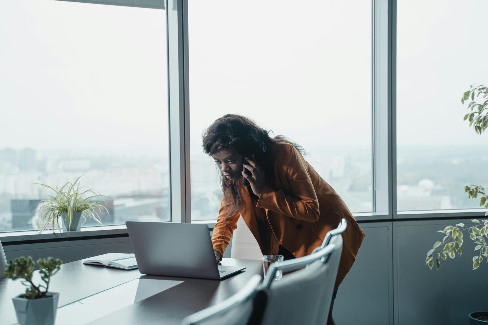 A business owner working at a laptop by a window